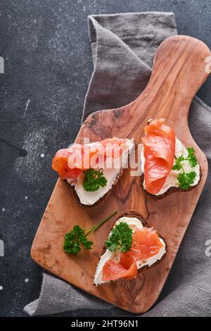 Mini sandwiches avec du saumon, du fromage caillé, du persil et du pain de seigle sous forme de coeurs.Saint-Valentin cuisine créative maison.J'adore le design du petit déjeuner.Séle Banque D'Images