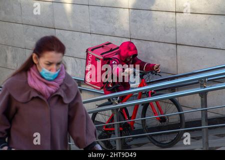 Moscou, Russie. 27th février 2022 les personnes qui ont fourni des services de livraison de nourriture populaire 'Samokat.Ru' livrez une commande sur la rue Tverskaya dans le centre de Moscou, en Russie Banque D'Images