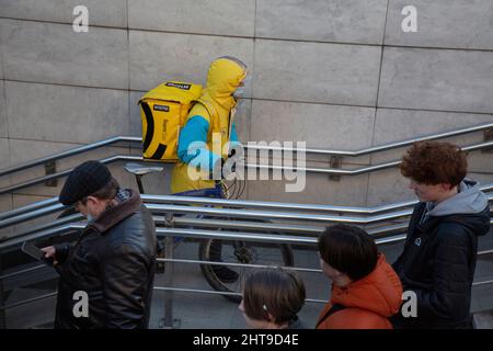 Moscou, Russie. 27th février 2022 le courrier des services populaires de livraison de nourriture 'Yandex EDA' livre une commande sur la rue Tverskaya dans le centre de la ville de Moscou, Russie Banque D'Images