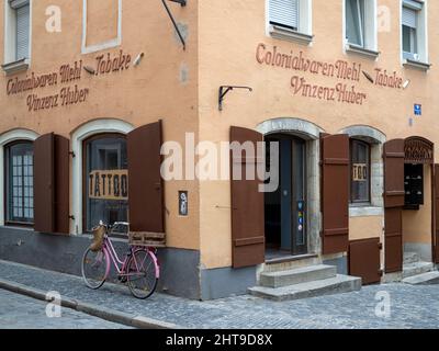 RATISBONNE, ALLEMAGNE - 11 JUILLET 2019: Vélo garée à côté de joli bâtiment dans la vieille ville avec des volets en bois et de vieux panneaux Banque D'Images