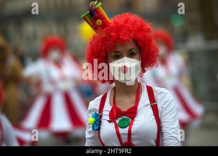 Malaga, Espagne. 27th févr. 2022. Une femme habillée de clown se produit lorsqu'elle participe à la parade du carnaval.les fêtards et les flotteurs prennent les rues de Malaga célébrant le carnaval depuis la détente des restrictions pendant la pandémie de la maladie COVID-19. Des milliers de personnes célèbrent le carnaval habillé comme des personnages différents ou représentant des problèmes sociaux. Crédit : SOPA Images Limited/Alamy Live News Banque D'Images