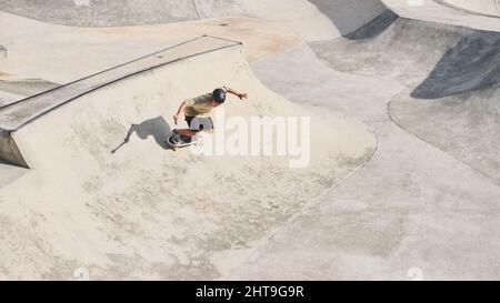 Cool Guy skateboard dans un parc à roulettes à Selangor, Malaisie tout en enregistrant une vidéo sur son téléphone Banque D'Images