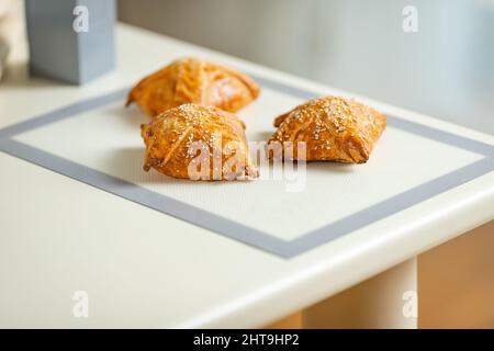 Une samosa fraîchement cuite sur un tapis de cuisson sur une table de cuisine maison. Banque D'Images