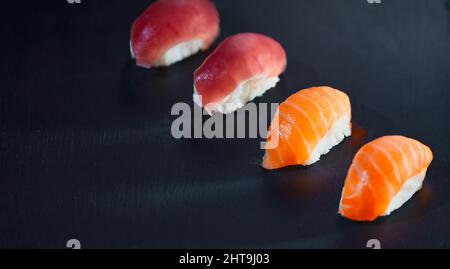 Vue en grand angle des quatre sushis préparés sur fond noir. Concept de nourriture japonaise et de saine alimentation. Banque D'Images