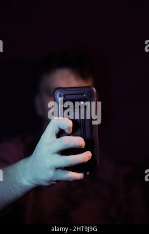 Photo verticale de la main d'un homme avec un smartphone tout en prenant un selfie Banque D'Images