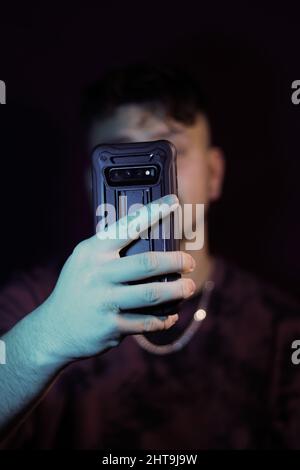 Photo verticale de la main d'un homme avec un smartphone tout en prenant un selfie Banque D'Images