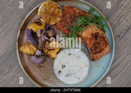 Assiette à dîner copieuse de saumon grillé, de riz blanc et de chou-fleur coloré sur une assiette. Banque D'Images