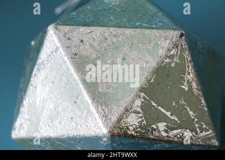 Figure géométrique, icosaèdre argenté, isolée sur fond bleu Banque D'Images