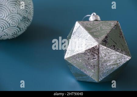 Figure géométrique, icosaèdre argenté, isolée sur fond bleu Banque D'Images