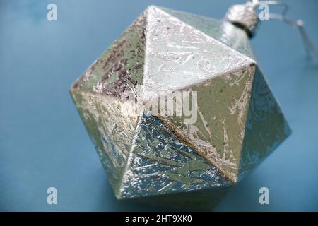 Figure géométrique, icosaèdre argenté, isolée sur fond bleu Banque D'Images