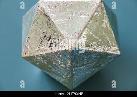 Figure géométrique, icosaèdre argenté, isolée sur fond bleu Banque D'Images
