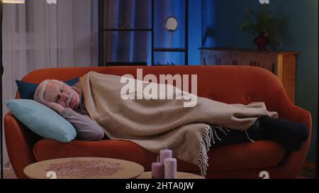 Homme âgé souriant grand-père dormant tranquillement allongé sur le lit à la maison, sain bon sommeil paisible Banque D'Images