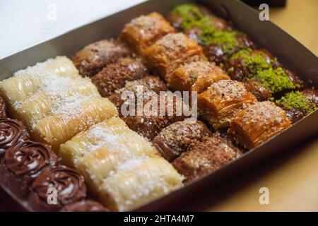 Gros plan de la baklava du Moyen-Orient avec des noix et des pistaches sur fond de bois Banque D'Images