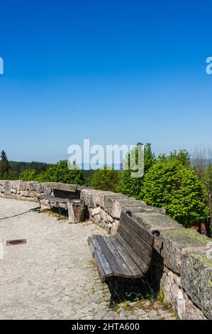 Plan vertical de bancs en bois le long d'une barrière en pierre dans un parc Banque D'Images