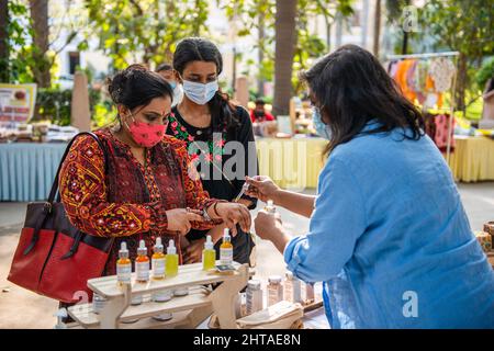 New Delhi, Inde. 27th févr. 2022. Les femmes testent le parfum tout en faisant des achats dans un marché du dimanche organisé par Bikaner House Management Society à New Delhi. Le 26 2022 février, le gouvernement de Delhi a levé toutes les restrictions de la COVID-19 en raison de la diminution du nombre d'infections à coronavirus. Crédit : SOPA Images Limited/Alamy Live News Banque D'Images