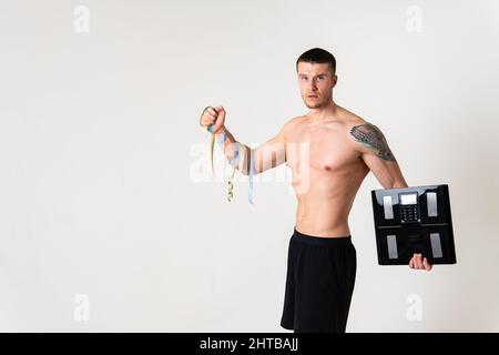 Homme avec des poids santé ponsé, santé et sports sur un fond blanc mal douloureux, malade homme médical, musclé touchant la maladie du cou, dos Banque D'Images