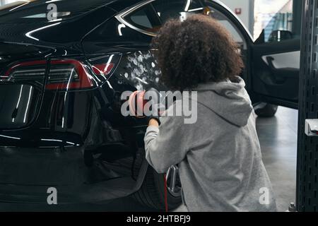 Auto detailer tamping véhicule client avec tampon voiture Banque D'Images