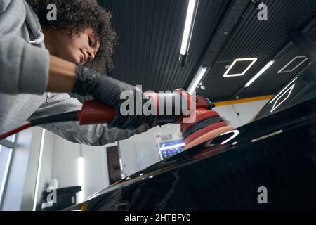 Ouvrier concentré de station-service sérieux polissage auto Banque D'Images