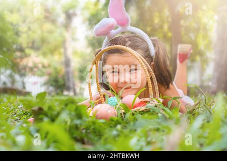 Portrait d'un enfant heureux dans les oreilles de lapin et panier de pâques dans l'arrière-cour Banque D'Images