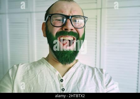 Choqué et heureux. Bonne journée de patrins de saint. Homme barbu à grands yeux ouverts célébrant la Saint patricks jour. Hipster dans un chapeau et un costume de lepreun. Ir Banque D'Images