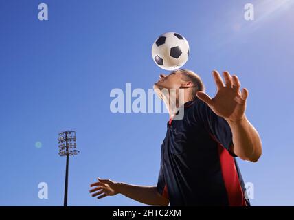 HES a des compétences. Tir d'un jeune footballeur qui rebondit une balle sur la tête. Banque D'Images