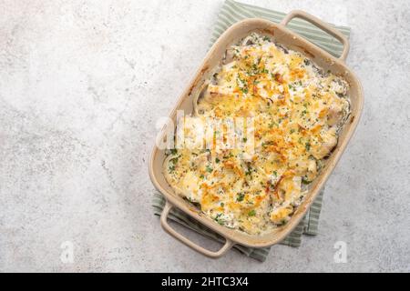 Cocotte de poisson blanc, chou-fleur, pomme de terre au fromage, crème sure et oignon Banque D'Images