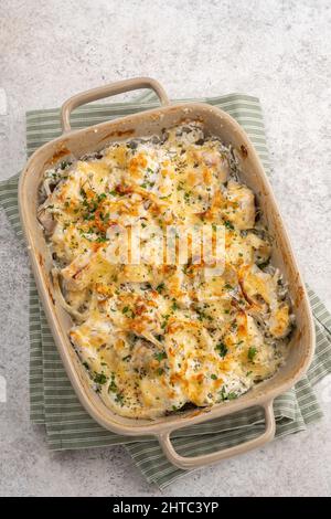 Cocotte de poisson blanc, chou-fleur, pomme de terre au fromage, crème sure et oignon Banque D'Images