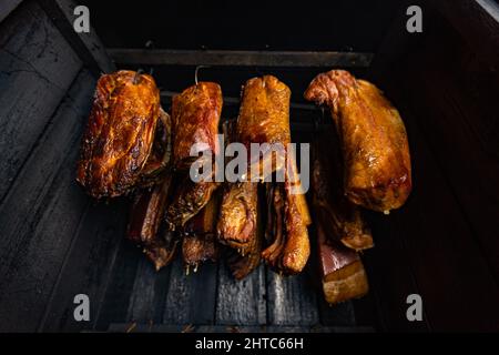 Gros plan de la viande fumée et du ventre ou de la viande de hêtre avec croûte foncée dans le fumoir ou fumoir, concept alimentaire Banque D'Images