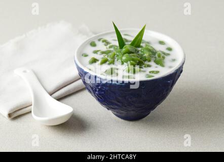 Es Cendol ou Dawet est un dessert traditionnel indonésien glacé à base de farine de riz, de sucre de palme, de lait de noix de coco et de feuilles de Pandan servi dans un bol bleu. Populaire Banque D'Images