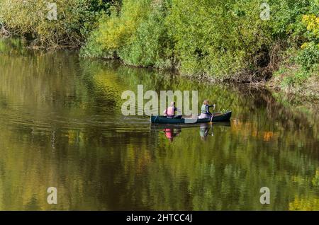 Les eaux fixes de la rivière Wye près de Whitney on Wye, Herefordshire, Royaume-Uni; deux personnes en canoë Banque D'Images