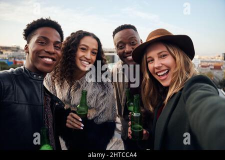 Portrait d'un groupe attrayant de jeunes adultes multiculturels qui se réunissent sur un toit-terrasse de la ville. Banque D'Images