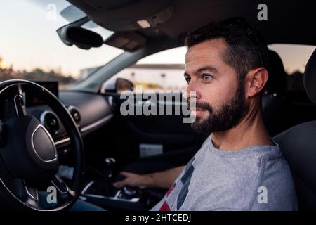 beau jeune homme assis au volant de sa voiture, de ses loisirs et de son concept de conduite Banque D'Images