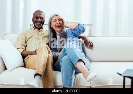 Image cinématographique d'un heureux couple multiethnique. Des moments de style de vie à l'intérieur à la maison. Concept de l'ancienneté et des relations Banque D'Images