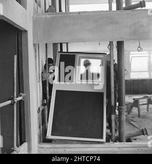 Restell Close, Greenwich, Londres, 29/04/1966. Travailleurs installant un panneau de fenêtre pendant la construction d'un bloc de 'sectra' de logements d'infirmières à Restell Close. Ce bloc résidentiel destiné aux infirmières était l'un des trois blocs de 10 étages en forme de H, construits par la société Laing's Construction pour la Commission de l'hôpital régional métropolitain du Sud-est, à l'aide du système 'sectra'. Les appartements ont été construits sur un point élevé juste au large de Vanbrugh Hill avec vue sur Greenwich, Deptford et la Tamise, fournissant des appartements autonomes de trois et quatre chambres pour les infirmières qui travaillaient à l'hôpital de Greenwich. Les blocs ont été nommés J Banque D'Images