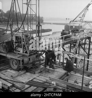 Pont Severn, M48, Aust, South Gloucestershire, 12/12/1961. Travailleurs de Laing utilisant un engin de forage monté sur camion sur les pontons temporaires sur le site des fondations de la tour Beachley du pont Severn. Cette photo a été utilisée dans le numéro de janvier 1962 de Team Spirit, la lettre d'information de la société Laing, avec la légende « Ground Engineering Limited: Rock-foring in connection with the Severn Bridge ». Le contrat de construction des fondations du pont Severn a été remporté par John Howard and Company, mais une partie du groupe Laing semble avoir été sous-traitée pour l'enquête Banque D'Images