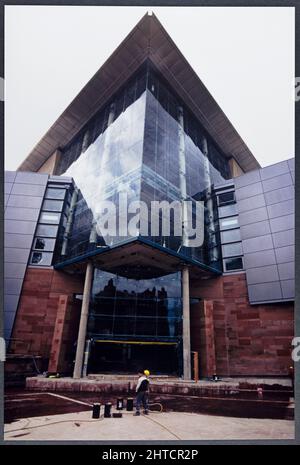 The Bridgewater Hall, place Barbirolli, Manchester, janvier-septembre 1996. Vue sur la saillie vitrée du foyer principal du Bridgewater Hall pendant sa construction, avec un ouvrier au premier plan. Le Bridgewater Hall a été conçu comme la maison de l'orchestre Hall&#xe9;. Les travaux sur le site ont commencé en septembre 1993. Le bâtiment a été construit en mars 1995 et il a été ouvert en septembre 1996. Banque D'Images