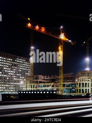 Vauxhall Cross, Albert Embankment, Vauxhall, Lambeth, Londres, 03/12/1990. Vue nocturne à l'est depuis le pont de Vauxhall pendant la construction de Vauxhall Cross, montrant l'une des grues sur place ornée de décorations de Noël illuminées. Vauxhall Cross, également connu sous le nom de SIS ou bâtiment MI6, a été conçu par l'architecte Terry Farrell et a été construit par Laing Management Contracting pour les propriétés régaliennes. Il a été vendu au gouvernement, devenant le siège social du Service britannique de renseignement secret ou MI6. Laing a gagné le contrat pour le bâtiment en 1989, avec le sol W. Banque D'Images