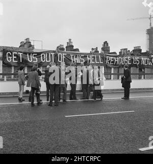 Westway Flyover, A40, Kensington et Chelsea, Londres, 28/07/1970. Michael Heseltine et un groupe de journalistes à l'ouverture de la Westway Flyover, avec une bannière de protestation drapée en arrière-plan. Michael Heseltine a été secrétaire parlementaire du ministère des Transports à l'époque et a défait pour le ministre John Peyton de couper la bande pour l'ouverture du survol de Westway. Le chemin Acklam a été le centre des protestations contre le Westway par les résidents locaux. Des maisons d'un côté de la rue avaient été démolies pour faire place au survol et à une réception tenue plus tôt ce jour-là au Lord&# Banque D'Images