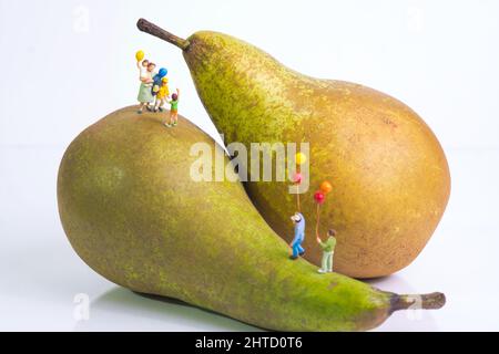 Une mère avec des enfants gaies est debout avec des ballons colorés sur les poires Banque D'Images