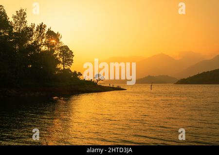 Magnifique vue sur le coucher du soleil avec le lac paisible et les montagnes comme arrière-plan, tiré du barrage de Wayanad Banasura Banque D'Images