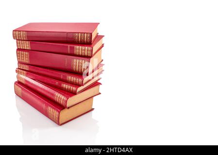 Pile de livres rouges vintage avec des décorations dorées sur une couverture en cuir dur, isolée sur blanc, chemin d'écrêtage, espace copie Banque D'Images