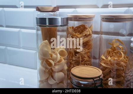 Variétés de pâtes dans des pots en verre avec pâtes à la pipe rigate au premier plan Banque D'Images