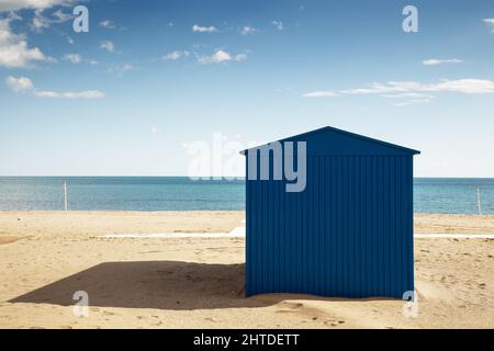 grand hangar bleu sur une plage de sable avec la mer derrière et un ciel bleu Banque D'Images