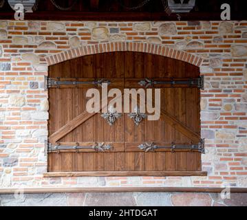 Porte en bois semi-circulaire avec poignées de porte en forme de fer et charnières de porte en forme de fer. Ancien beau bâtiment en briques, architecture Banque D'Images