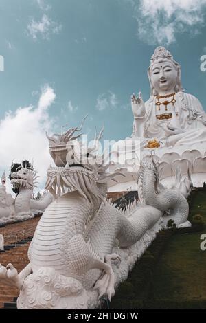 Photo verticale des statues asiatiques sur un bâtiment sous un ciel nuageux Banque D'Images