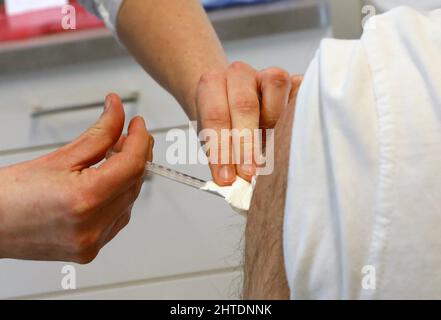 Rostock, Allemagne. 28th févr. 2022. Au service médical de l'entreprise du University Medical Center Rostock, une infirmière vaccine un homme contre Covid-19 avec le vaccin Nuvaxovid du fabricant américain Novavax. Le vaccin protéinique avec un rappel actif est une alternative bienvenue pour ceux qui sont méfiants d'autres vaccins à base d'ARNm. Credit: Bernd Wüstneck/dpa-Zentralbild/dpa/Alay Live News Banque D'Images