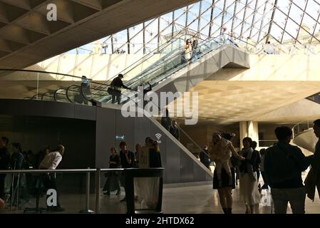 Salle principale pleine de personnes sous la pyramide de verre dans le Musée du Louvre, Paris, France Banque D'Images