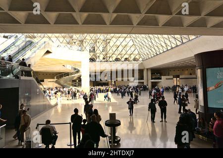 Salle principale pleine de personnes sous la pyramide de verre dans le Musée du Louvre, Paris, France Banque D'Images