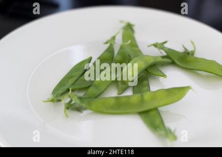 Haricots verts fraîchement cueillis sur une assiette Banque D'Images