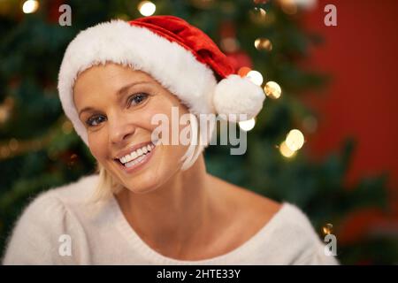 Grand sourire pour le père noël. Portrait d'une femme joyeuse portant un chapeau de noël. Banque D'Images